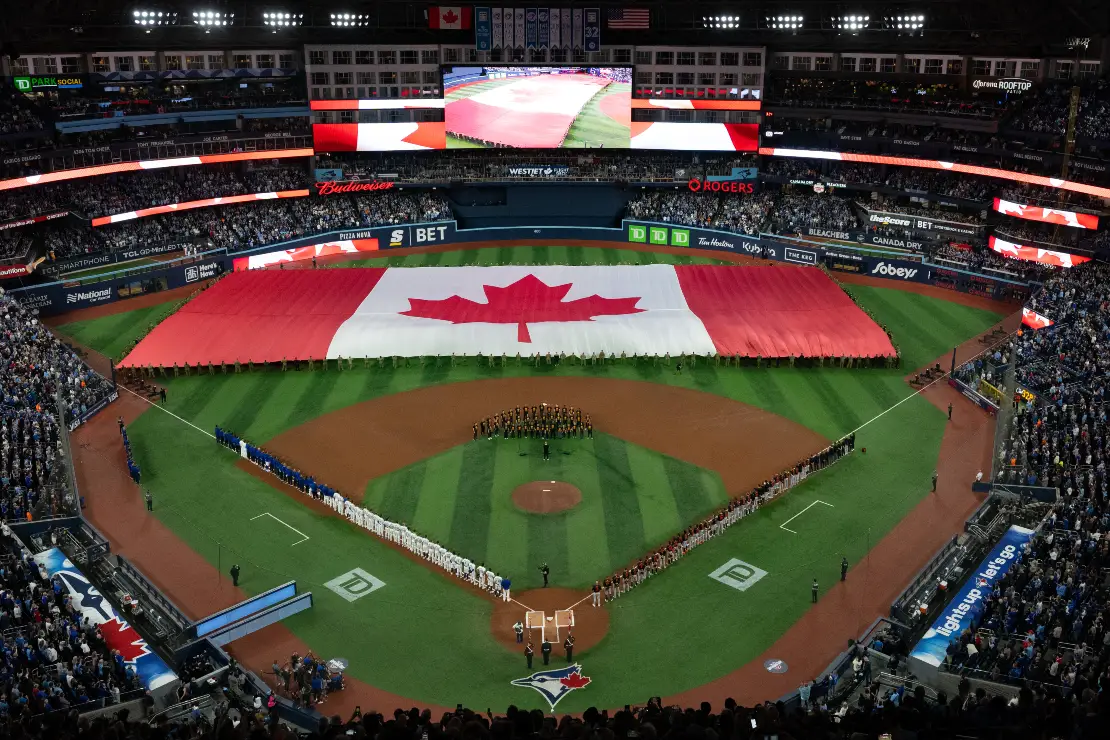 Fans and players stand for the Canadian national anthem ahead of the Toronto Blue Jays home opener against the Baltimore Orioles, in Toronto on Thursday, March 27, 2025. CP/Arlyn McAdorey